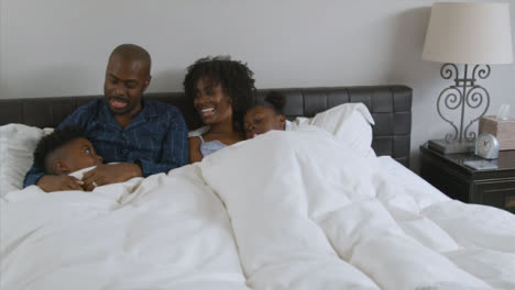 Children-Snuggling-In-Bed-with-Their-Parents