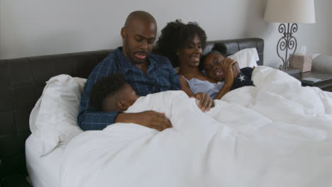 Children-Snuggling-with-Their-Parents-In-Bed