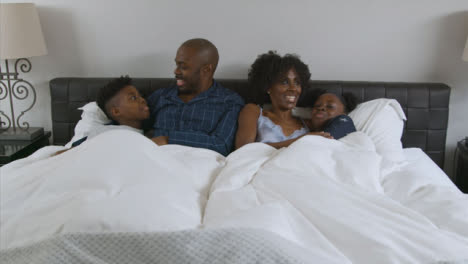 Young-Children-Snuggle-In-Their-Parents-Bed