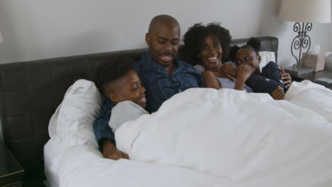 Parents-Children-Snuggle-with-Them-In-Their-Bed