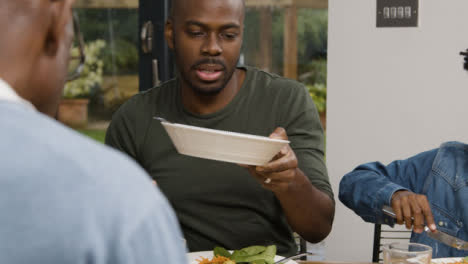 Middle-Aged-Man-Plating-Up-Potatoes-During-Family-Meal-