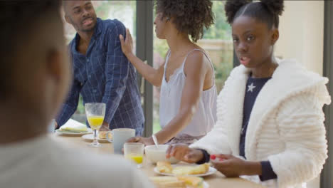 Family-Talking-and-Laughing-With-Each-Another-Over-Breakfast-at-Kitchen-Island