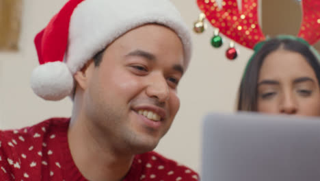 Close-Up-of-Couple-Talking-Into-Laptop-During-Christmas-Video-Call