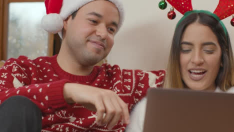 Rising-Close-Up-of-Couple-Talking-Into-Laptop-During-a-Christmas-Video-Call