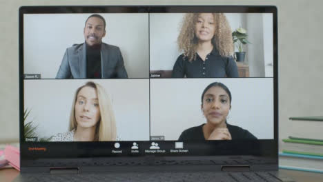 Sliding-Medium-Shot-of-Laptop-Screen-with-Four-People-In-Business-Video-Call