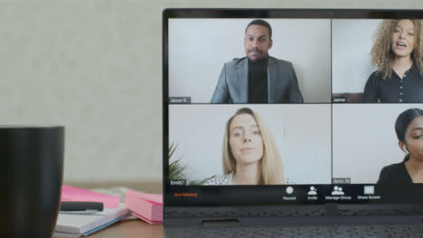 Sliding-Medium-Shot-of-Laptop-Screen-with-Four-People-In-a-Business-Video-Call
