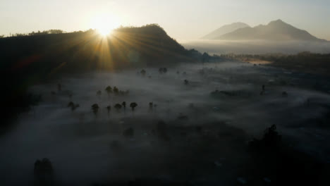 Drone-Shot-Orbiting-Low-Hanging-Mist-Around-Mount-Batur-Volcano