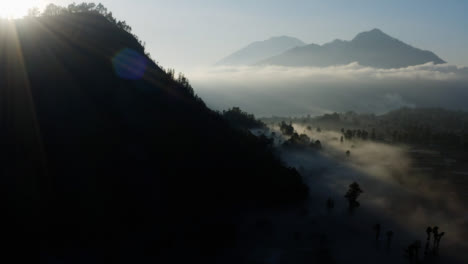 Drone-Shot-Flying-Over-Low-Hanging-Mist-Surrounding-Mount-Batur-