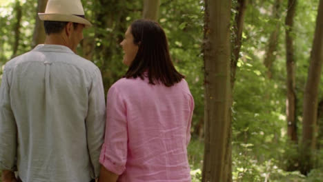 Tracking-Shot-Following-Middle-Aged-Couple-Walking-Through-Scenic-Woodland