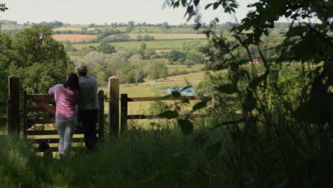 Panning-Shot-of-Middle-Aged-Couple-Looking-Out-at-Countryside-Valley