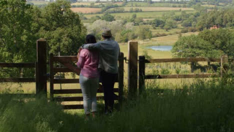 Tracking-Shot-Approaching-Middle-Aged-Couple-Looking-Out-at-Countryside-Valley
