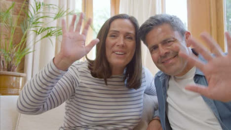 POV-Shot-of-Middle-Aged-Couple-Waving-Hello-to-Camera-During-Video-Call