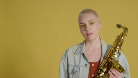 Portrait-Shot-of-Model-Smiling-to-Camera-Whilst-Holding-Alto-Saxophone