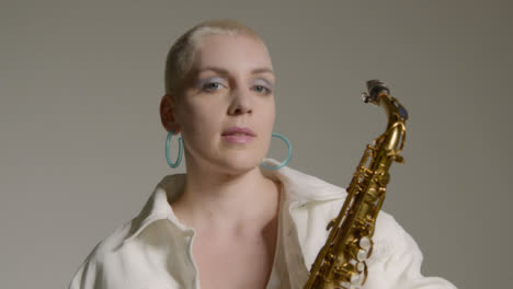 Portrait-Shot-of-Female-Model-Looking-Straight-to-Camera-While-Holding-Saxophone