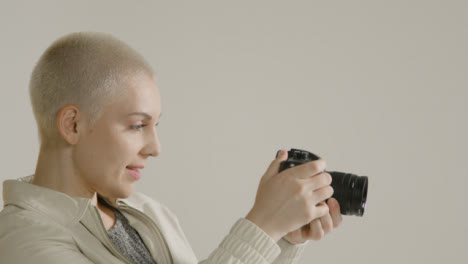 Side-view-of-a-young-woman-using-a-dslr-camera