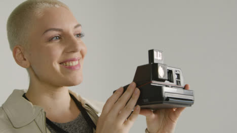 Side-view-of-a-female-photographer-posing-with-instant-film-camera-02