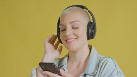 Female-caucasian-model-listening-to-music-on-headphones-studio-portrait-07