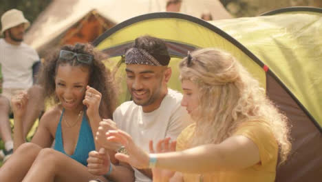 Medium-Shot-of-Young-Festival-Goers-Joking-and-Dancing-by-Their-Tent