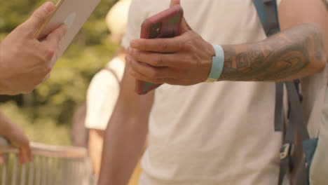 Close-Up-Shot-of-Festival-Goers-Showing-Electronic-Tickets-to-Security-Guard