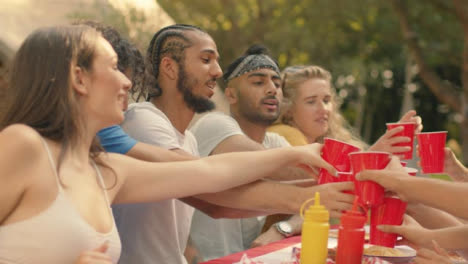 Medium-Shot-of-Group-of-Friends-Sitting-Around-Table-Talking-and-Drinking