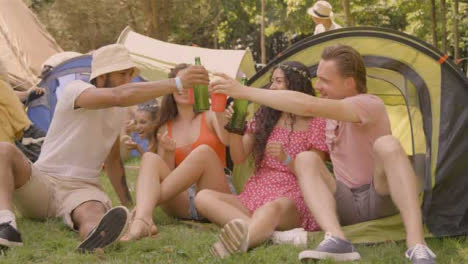 Sliding-Shot-of-Some-Young-Festival-Goers-Sitting-Down-Drinking-and-Talking
