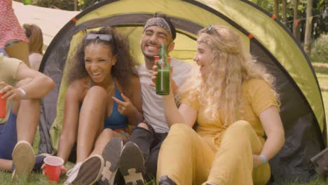 Medium-Shot-of-Festival-Goers-Drinking-and-Talking-by-Their-Tent