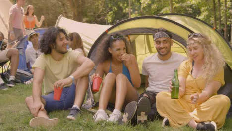 Sliding-Shot-of-Some-Festival-Goers-Drinking-and-Talking-by-Their-Tent