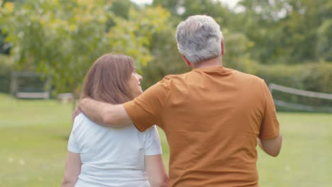 Tracking-Shot-Following-Senior-Couple-Walking-Through-Lush-Gardens