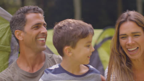 Tracking-Shot-of-Family-On-Camping-Trip-Sitting-and-Talking-by-Their-Tents-05