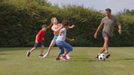 Tracking-Shot-of-Adult-Playing-Football-with-Group-of-Children-01