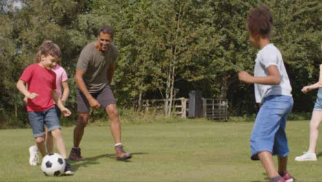 Tracking-Shot-of-Adult-Playing-Football-with-Group-of-Children-02