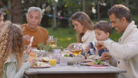 Kamerafahrt-Einer-Familie-Beim-Abendessen-Im-Freien-03