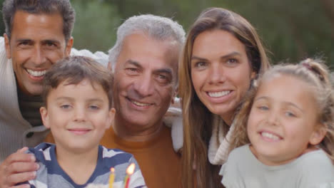 Porträtaufnahme-Einer-Familie,-Die-Mit-Einem-Geburtstagskuchen-Lächelt