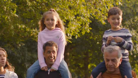 Tracking-Shot-of-Children-Sitting-On-Their-Parents-and-Grandparents-Shoulders-02