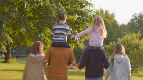 Tracking-Shot-of-Children-Sitting-On-Their-Parents-and-Grandparents-Shoulders-05