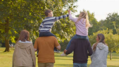 Tracking-Shot-of-Children-Sitting-On-Their-Parents-and-Grandparents-Shoulders-06