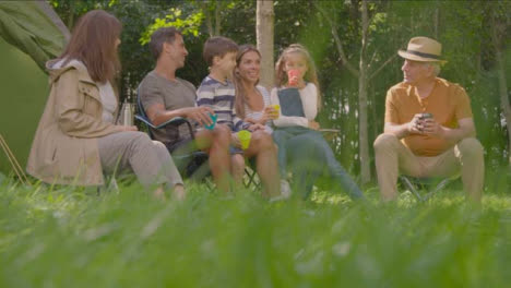 Low-Angle-Shot-of-Family-Sitting-by-Tent-On-Camping-Holiday-01