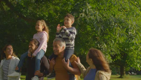 Tracking-Shot-of-Children-Riding-On-Their-Family's-Shoulders-01