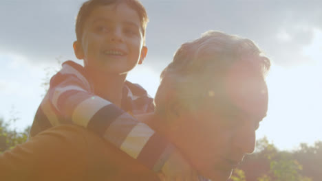 Portrait-Shot-of-Young-Boy-Getting-Piggy-Back-from-His-Grandfather-01