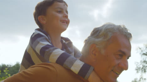 Portrait-Shot-of-Young-Boy-Getting-Piggy-Back-from-His-Grandfather-02