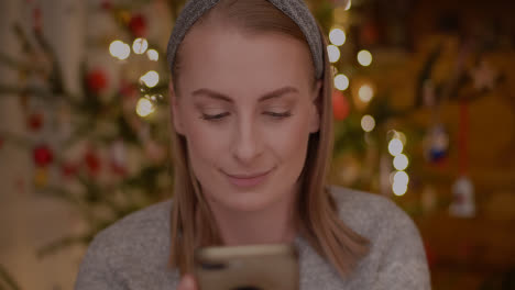 Young-Woman-Browsing-Internet-On-Smartphone-At-Home