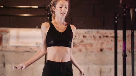 Slow-Motion-Of-Confident-Young-Woman-Exercising-Using-Skipping-Rope-At-Gym