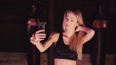 Sportlerin,-Die-Haare-Anpasst,-Während-Sie-Im-Fitnessstudio-Ein-Selfie-über-Das-Smartphone-Macht?