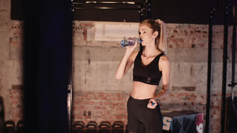 Young-Female-Athlete-Drinking-Water-From-Bottle-After-Workout-Session-At-Health-Club-2