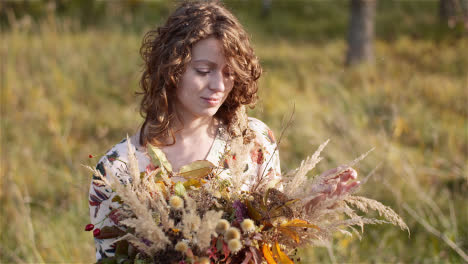 Plano-Medio-De-Una-Mujer-Mirando-El-Ramo-De-Flores-Silvestres-En-Verano