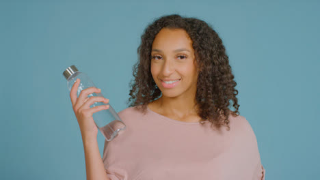 Portrait-Shot-of-Young-Adult-Woman-Smiling-with-Water-Bottle