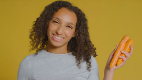 Portrait-Shot-of-Young-Adult-Woman-Holding-Carrots