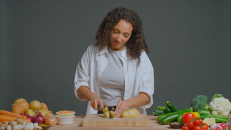 Wide-Shot-of-Young-Adult-Woman-Slicing-Potato