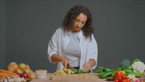 Wide-Shot-of-Young-Adult-Woman-Slicing-Cucumber