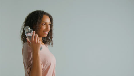 Side-Profile-Shot-of-Young-Adult-Woman-Smiling-Off-Camera-with-Water-Bottle